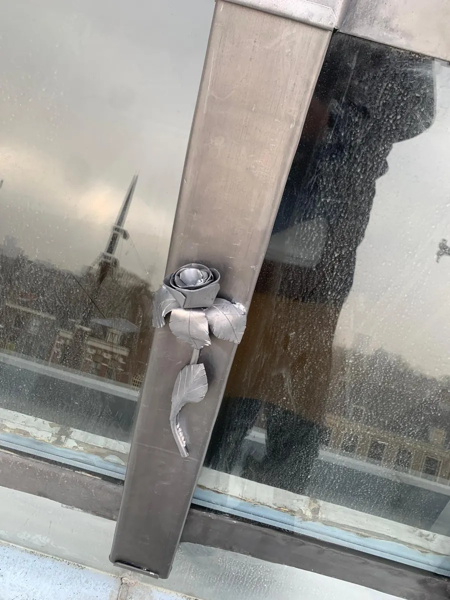 Metalen roos als decoratief detail aan een dakraam