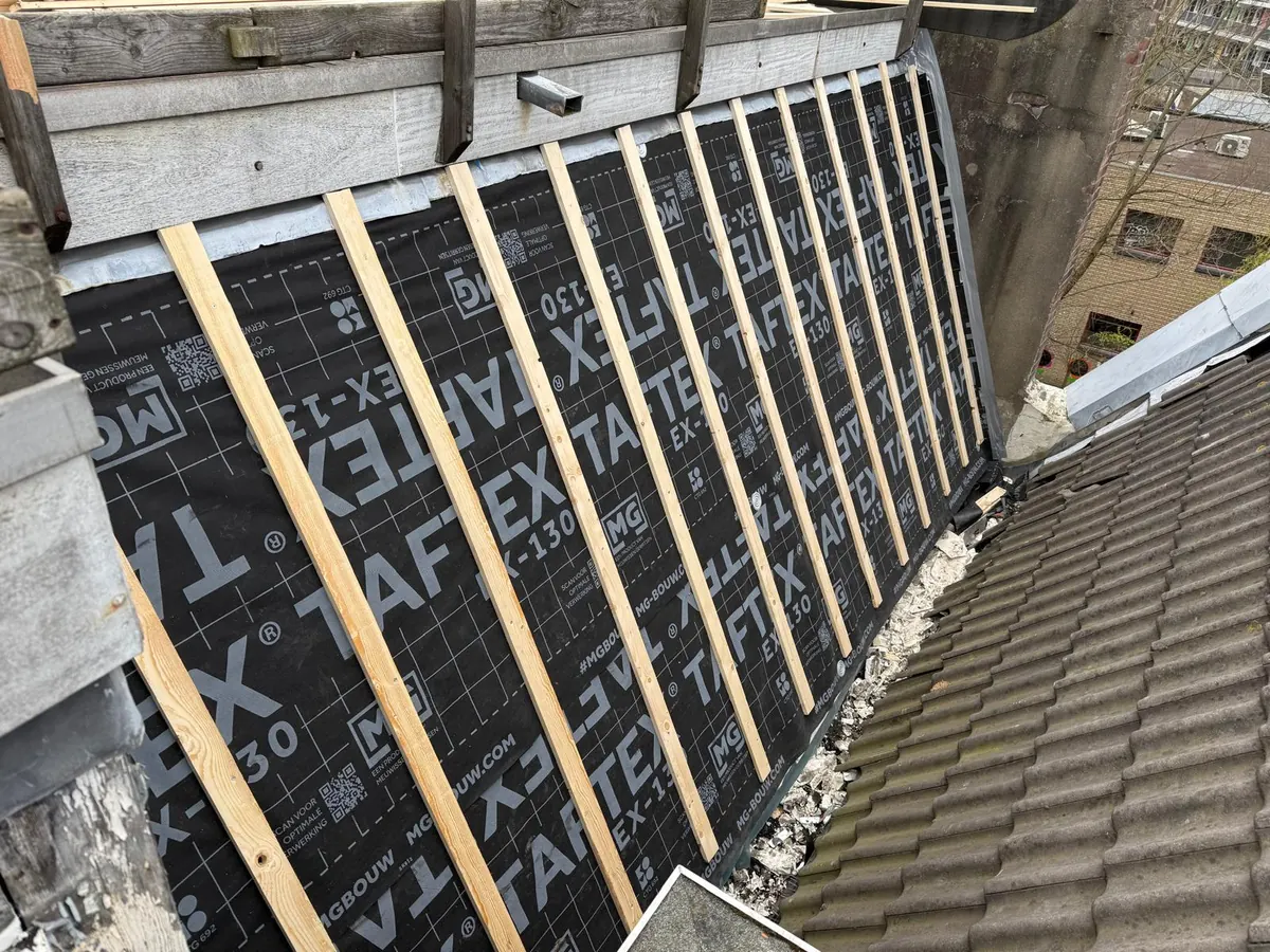Dakfolie en houten panlatten bij een pannendak langs een dakterras